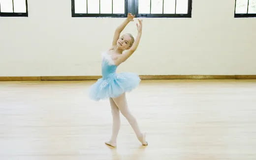 a girl wearing a blue dress and ice skates on ice