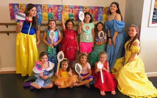 a group of girls in dresses and dresses posing for a photo