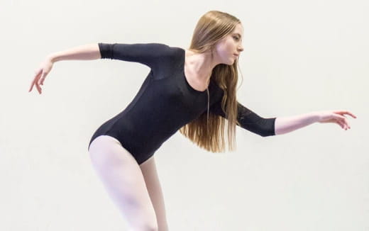 a woman in a black leotard with her arms out