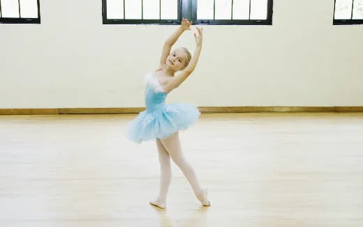 a girl wearing a blue dress and ice skates on ice