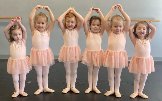 a group of girls in pink dresses