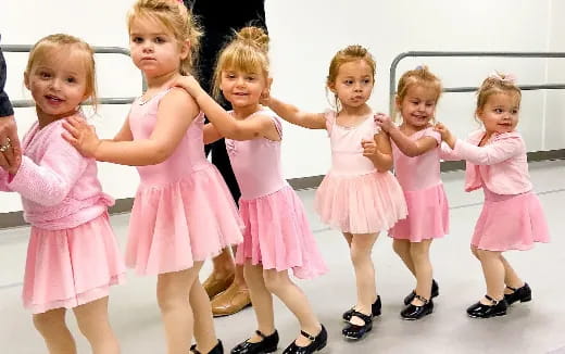 a group of girls in pink dresses