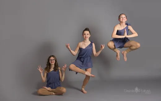 a group of people in blue dresses jumping in the air