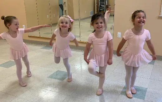 a group of girls in dresses dancing