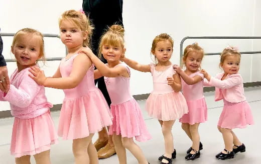 a group of girls in pink dresses