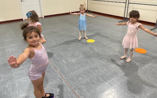 a group of girls in dresses dancing