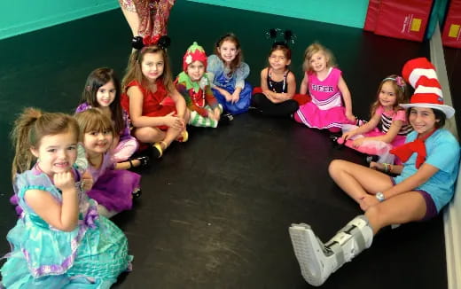 a group of children sitting on the floor wearing christmas hats