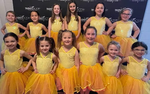 a group of girls in yellow dresses