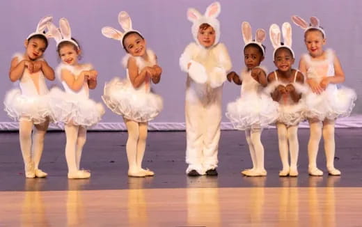 a group of girls wearing bunny ears and standing on a stage