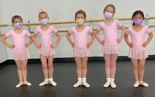 a group of girls wearing pink dresses