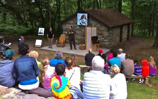 a group of people sitting in chairs watching a person speak to a group of people