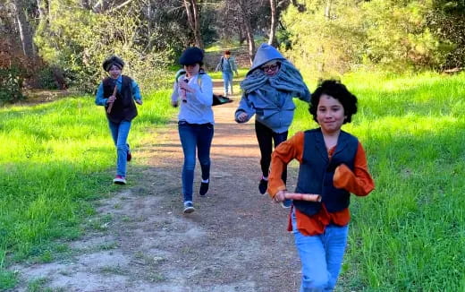 a group of people running on a path in a forest