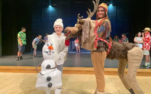 a person and a couple of people in clothing on a stage