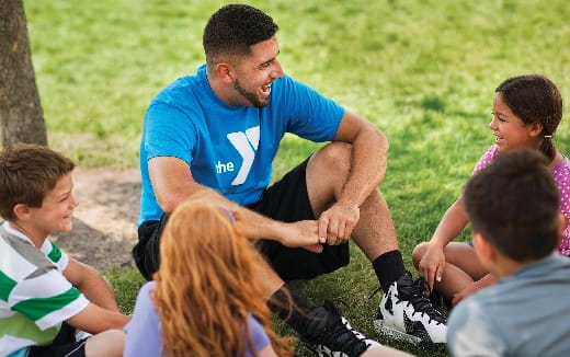 a man kneeling in front of a group of children