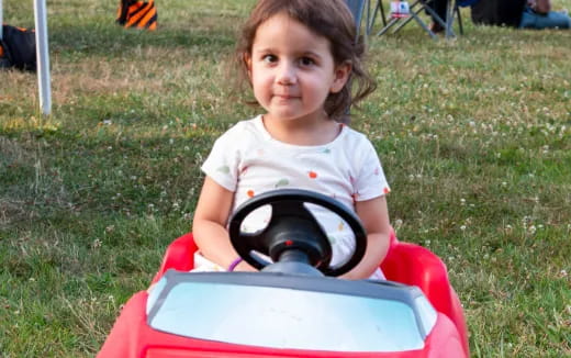 a girl sitting on a toy car