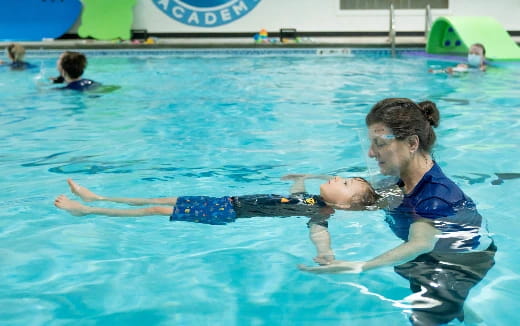 a man in a pool with a baby in the pool