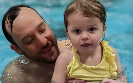 a person and a baby in a pool