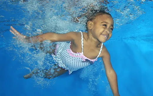 a young boy swimming in a pool