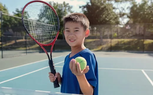 a boy holding a tennis racket