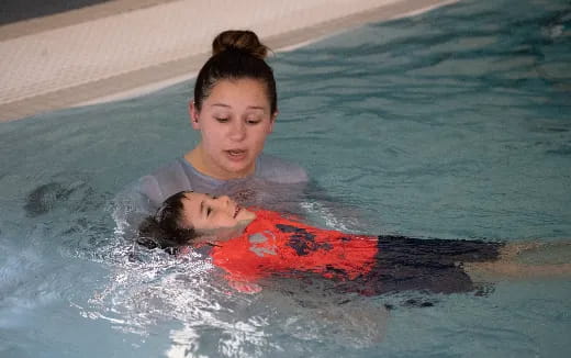 a person and a baby in a pool