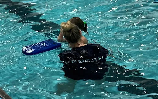 a person in the water with a surfboard