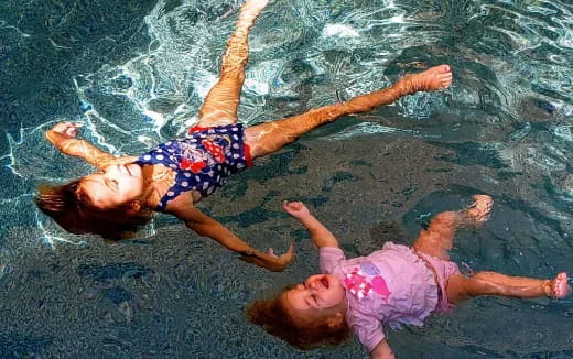 a couple of girls swimming in water