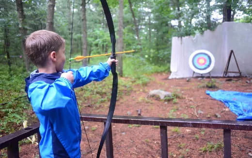 a boy shooting a bow and arrow