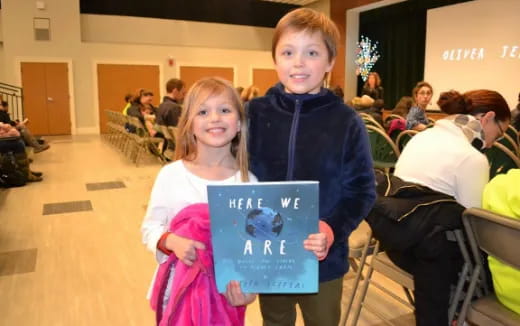 a boy and girl holding a sign