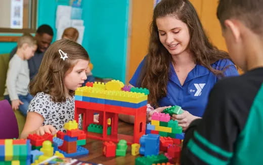 a person and a child playing with a toy building