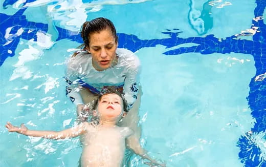 a person and a boy in a pool