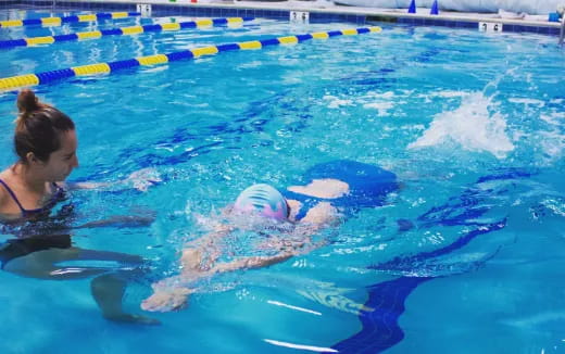 a person in a pool with a dolphin in it