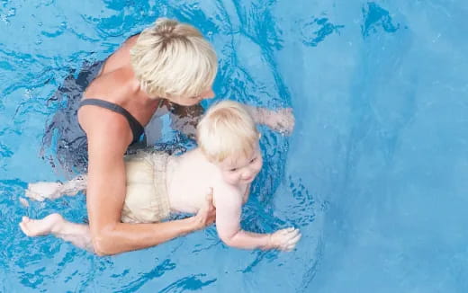 a person and a baby in a pool