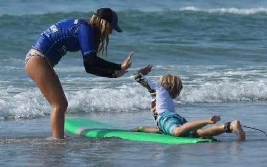a person and a child surfing in the sea