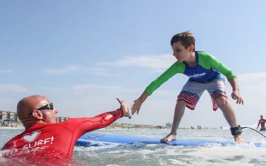 a person and a child on a surfboard