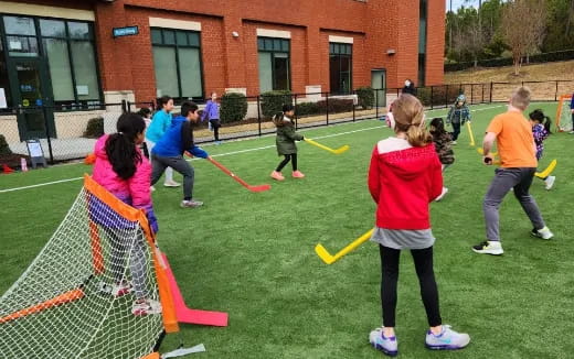 a group of people playing with bows and arrows outside a building