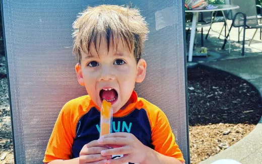 a boy eating a hot dog