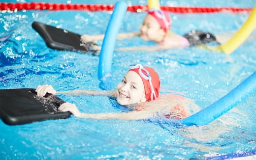 a group of kids swimming in a pool