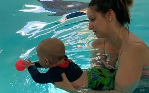 a person and a baby in a pool