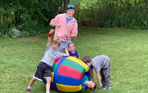 a group of people playing with a large ball in a grassy area