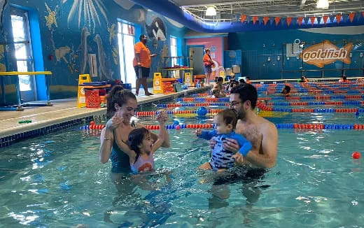 a man and woman with a couple of children in a pool