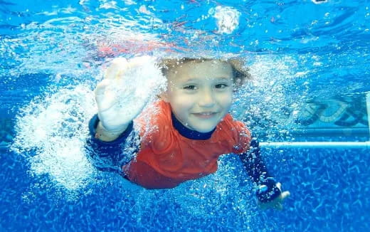 a boy swimming in a pool