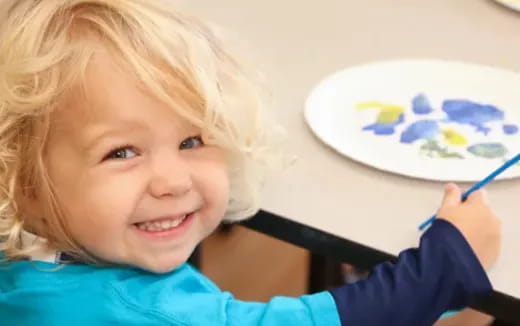 a child painting on a white board