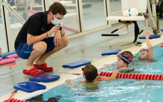 a person taking a picture of a boy in a pool