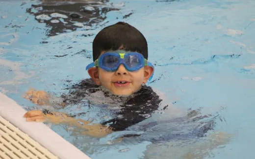 a boy wearing goggles in a pool