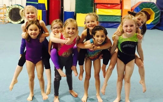 a group of girls in leotards on a stage