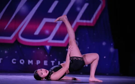 a woman doing a handstand on a stage
