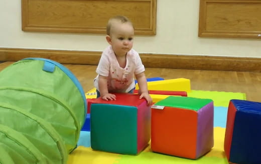 a baby sitting on a colorful play set