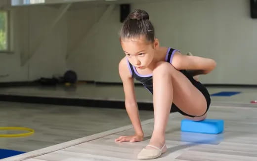 a young girl stretching on a mat