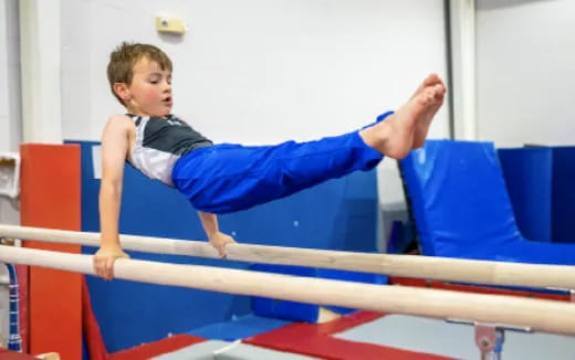 a boy jumping over a bar