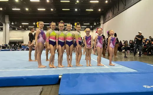 a group of women in swimsuits standing on a mat